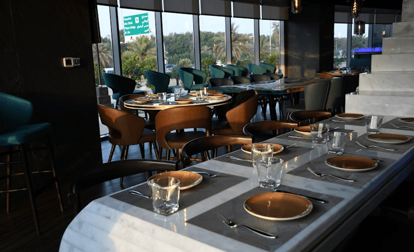 Upscale hotel restaurant interior with marble tables and lounge seating